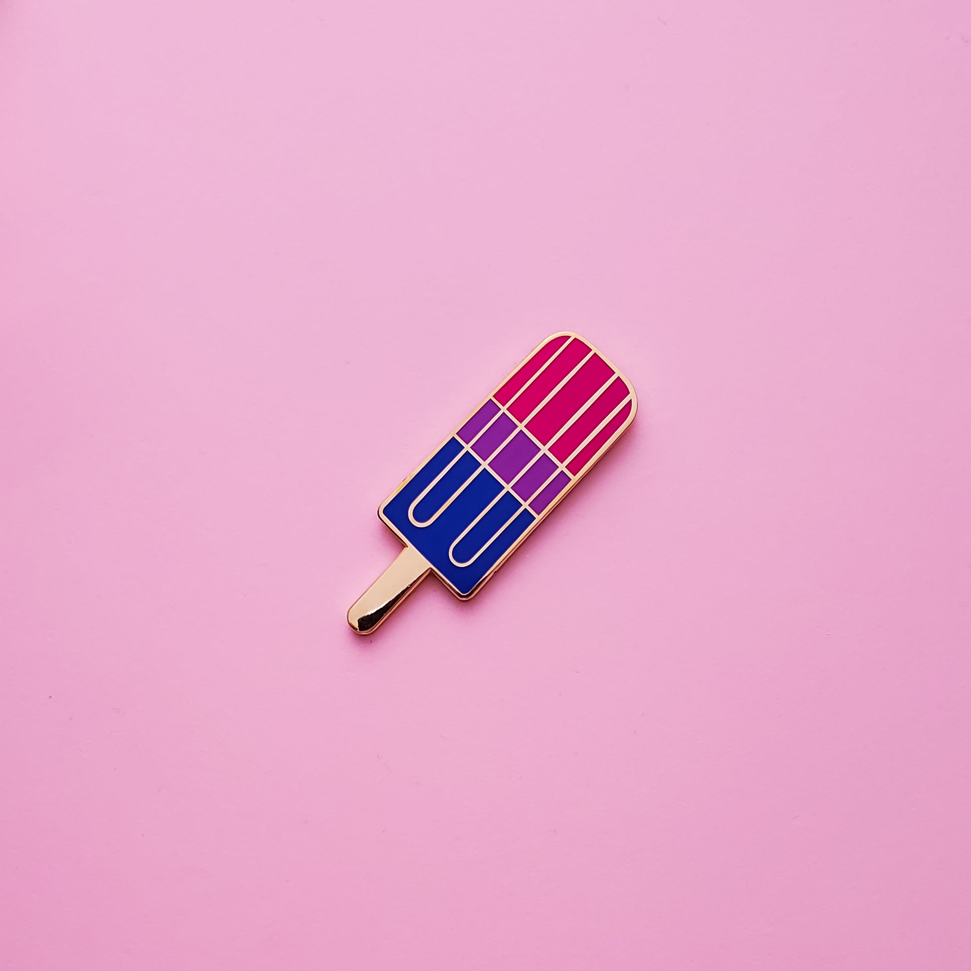 Bisexual Pride Popsicle Pin on a pink background. Pin is has vibrant bisexual pride colours set in a polished nickle metal. Bisexual pride pin colours are pink, purple and blue.Bisexual Popsicle Pin - LGBTQ Pins Canada | Little Rainbow Paper Co